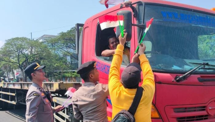 HUT ke-81 RI, Polres Pelabuhan Tanjung Perak Bagikan Bendera Merah Putih kepada Pengendara